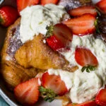 Wentelteefjes van croissants met vanilleroom en verse aardbeien
