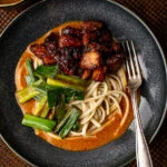 Udon in gele curry met plakkerige speklapjes